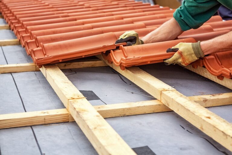 roofer at work, installing clay roof tiles, germany